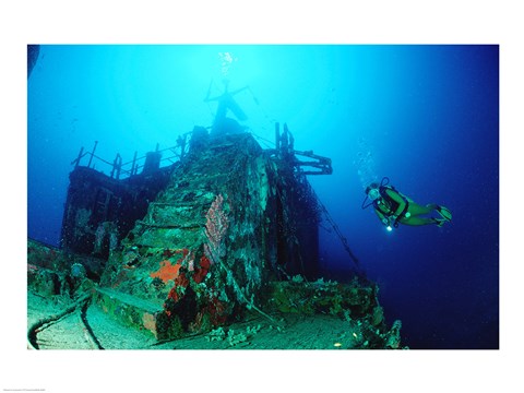 Framed Scuba diver watching a shipwreck underwater Print