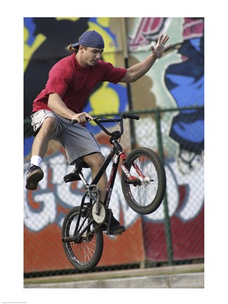 Framed Low angle view of a teenage boy performing a stunt on a bicycle Print