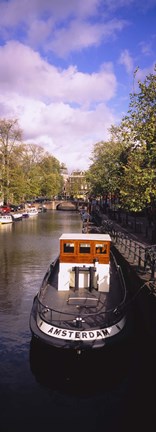 Framed Tourboat docked in a channel, Amsterdam, Netherlands Print