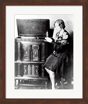 Framed Young woman sitting beside an RCA Radio-Phonograph and Home Recorder Print