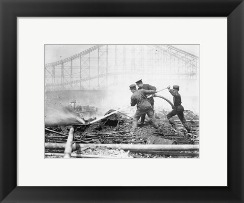 Framed Three firefighters extinguishing a fire Print