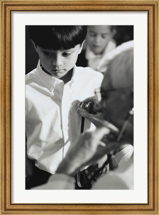 Framed Male doctor listening to a boy&#39;s heartbeat Print