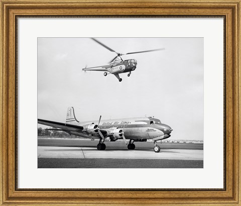 Framed Low angle view of a helicopter in flight and an airplane at an airport, Sikorsky Helicopter, Douglas DC-4 Print