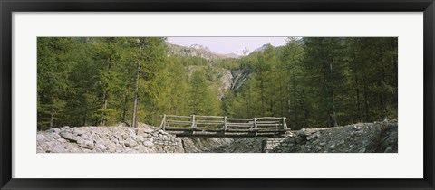 Framed Wooden footbridge across a stream in a mountain range, Switzerland Print