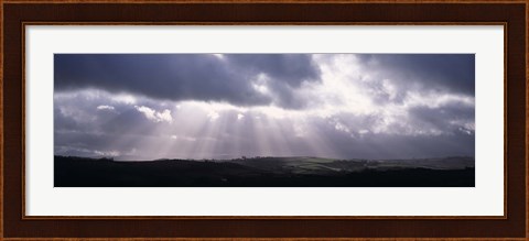 Framed Sunbeams radiating through dark clouds over rolling hills, Dartmoor, Devon, England Print