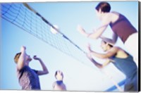 Low angle view of two young couples playing beach volleyball Fine Art Print