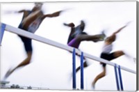 Low angle view of three men jumping over a hurdle Fine Art Print