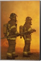 Rear view of two firefighters extinguishing a fire Fine Art Print