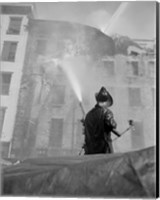 Firefighter pouring water on burning building, low angle view Fine Art Print
