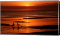 Silhouette of a young couple cycling on the beach Fine Art Print