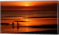 Silhouette of a young couple cycling on the beach Fine Art Print