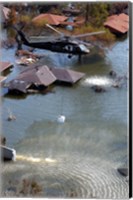 A Blackhawk helicopter drops sandbags into an area where the levee broke due to Hurricane Katrina Fine Art Print