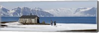 Two hikers standing on the beach near a hunting cabin, Bellsund, Spitsbergen, Svalbard Islands, Norway Fine Art Print