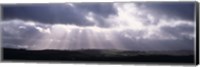 Sunbeams radiating through dark clouds over rolling hills, Dartmoor, Devon, England Fine Art Print