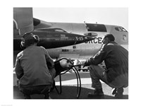 Rear view of two men crouching near fighter planes, X-15 Rocket Research Airplane, B-52 Mothership Fine Art Print