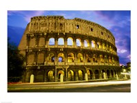 Low angle view of the old ruins of an amphitheater lit up at dusk, Colosseum, Rome, Italy Framed Print