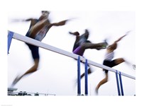 Low angle view of three men jumping over a hurdle Fine Art Print