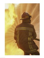 Rear view of a firefighter extinguishing a fire Fine Art Print