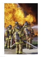 Rear view of a group of firefighters extinguishing a fire vertical Fine Art Print
