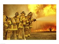 Rear view of a group of firefighters extinguishing a fire Fine Art Print