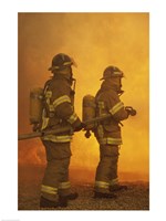 Rear view of two firefighters extinguishing a fire Fine Art Print