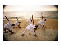 Group of people performing yoga on the beach Fine Art Print