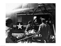 Army soldiers carrying an injured person in a helicopter Fine Art Print