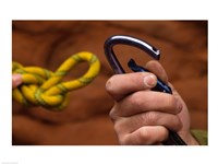 Close-up of human hands holding a carabiner and rope - various sizes