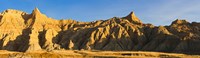 Sculpted sandstone spires in golden light, Saddle Pass Trail, Badlands National Park, South Dakota, USA by Panoramic Images - 36" x 12"