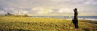USA, California, Businessman standing holding binoculars and looking at the lighthouse by Panoramic Images - 36" x 12"