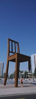 Woman standing under a sculpture of large broken chair, Geneva, Switzerland Fine Art Print