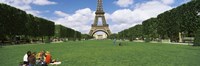 Tourists sitting in a park with a tower in the background, Eiffel Tower, Paris, Ile-de-France, France Fine Art Print