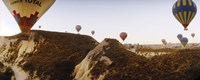 Hot air balloons soaring over a mountain ridge, Cappadocia, Central Anatolia Region, Turkey Fine Art Print