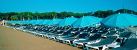 Parasols with lounge chairs on a private beach in summer morning light, French Riviera, France Fine Art Print