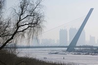 Songhuajiang Highway Bridge over the frozen Songhua River with buildings in the background, Harbin, Heilungkiang Province, China Fine Art Print