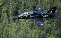 A Hawk T1 trainer aircraft of the Royal Air Force flying over a forest in North Wales Fine Art Print