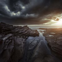 Huge rocks on the shore of a sea against stormy clouds, Sardinia, Italy Fine Art Print