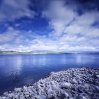 Tranquil lake and rocky shore against cloudy sky, Sardinia, Italy Fine Art Print