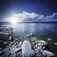 Tranquil lake and rocky shore with sun over horizon, Sardinia, Italy Fine Art Print