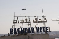 An AH-64 Apache in flight over the Baghdad Hotel in central Baghdad, Iraq Fine Art Print