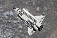 Aerial view of Space Shuttle Discovery over Earth as it approaches the International Space Station Fine Art Print