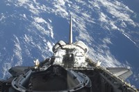 A partial view of Space Shuttle Atlantis Backdropped by a Blue and White Earth - various sizes