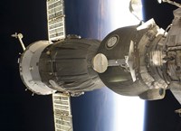 A Soyuz spacecraft backdropped by Earth Fine Art Print