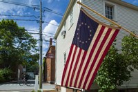 New Hampshire, Portsmouth, Strawberry Banke Historic Area, building with US flag Fine Art Print