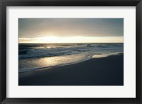 Waves breaking on the beach at sunrise Framed Print