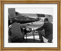Rear view of two men crouching near fighter planes, X-15 Rocket Research Airplane, B-52 Mothership Fine Art Print