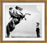 Low angle view of a cowboy riding a bucking horse Fine Art Print