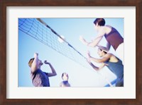 Low angle view of two young couples playing beach volleyball Fine Art Print