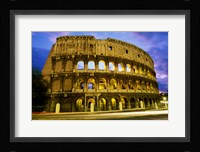 Low angle view of the old ruins of an amphitheater lit up at dusk, Colosseum, Rome, Italy Framed Print