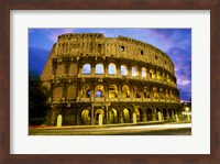 Low angle view of the old ruins of an amphitheater lit up at dusk, Colosseum, Rome, Italy Fine Art Print